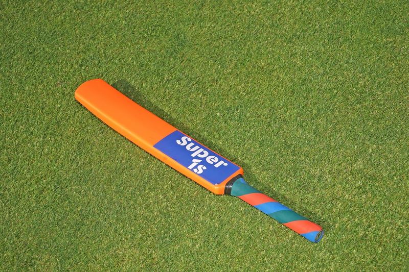 Cricket bat laying flat on the grass