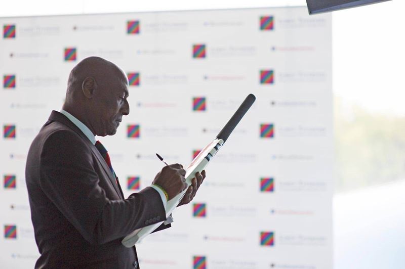 Man signing a cricket bat