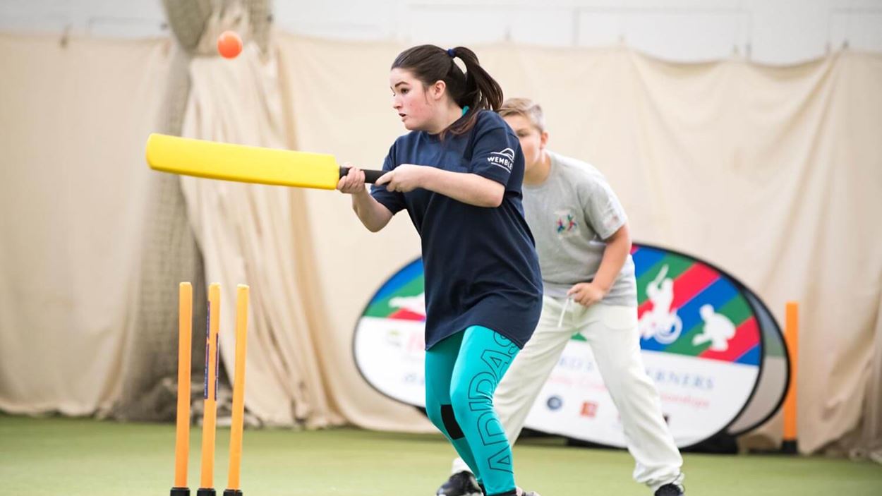 Girl hitting the ball in super 1's final cricket match