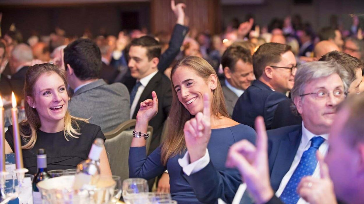 Audience raising hand at event