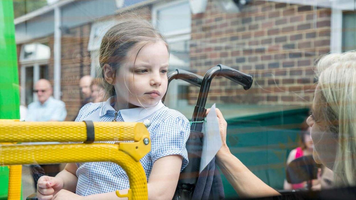 Little girl in wheel chair beind put onto a minibus