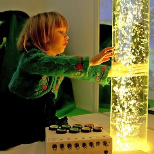 Little girl playing with a lava lamps