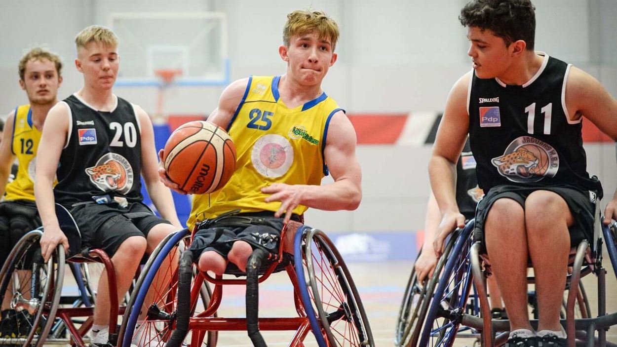Action shot of a boy as he makes it down the court in the wheelchair basketball tournament