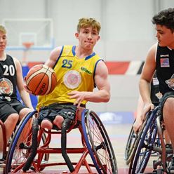 Action shot of a boy as he makes it down the court in the wheelchair basketball tournament