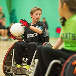 Boy about to pass the ball in wheelchair rugby