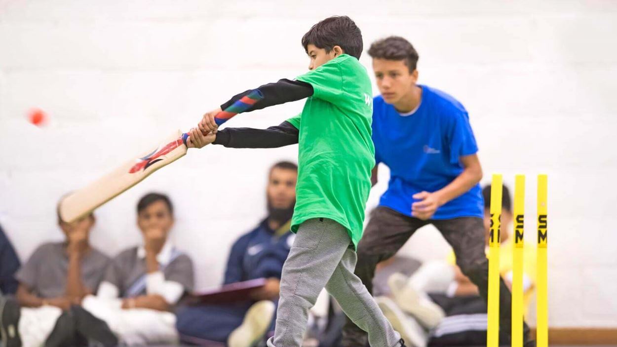 Little boy striking a circket ball