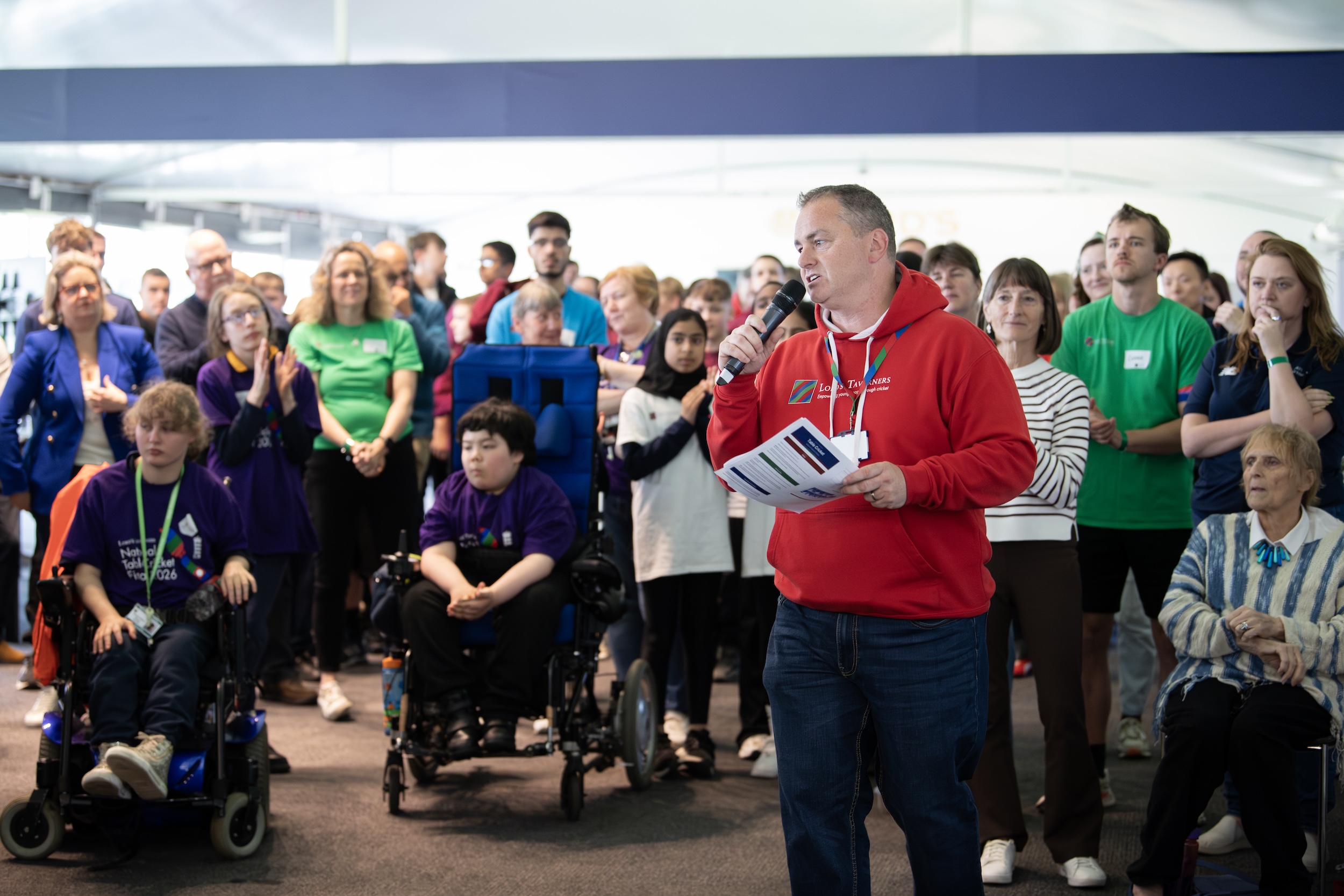 CEO Mark Curtin speaking into a microphone in the Nursery Pavilion at Lord's in front of National Table Cricket Finals participants and guests.jpg