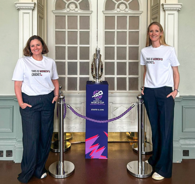 Leigh and Katy wearing 'This is Women's Cricket' tees in the Long Room at Lord's with the ICC Women's T20 World Cup Trophy.png
