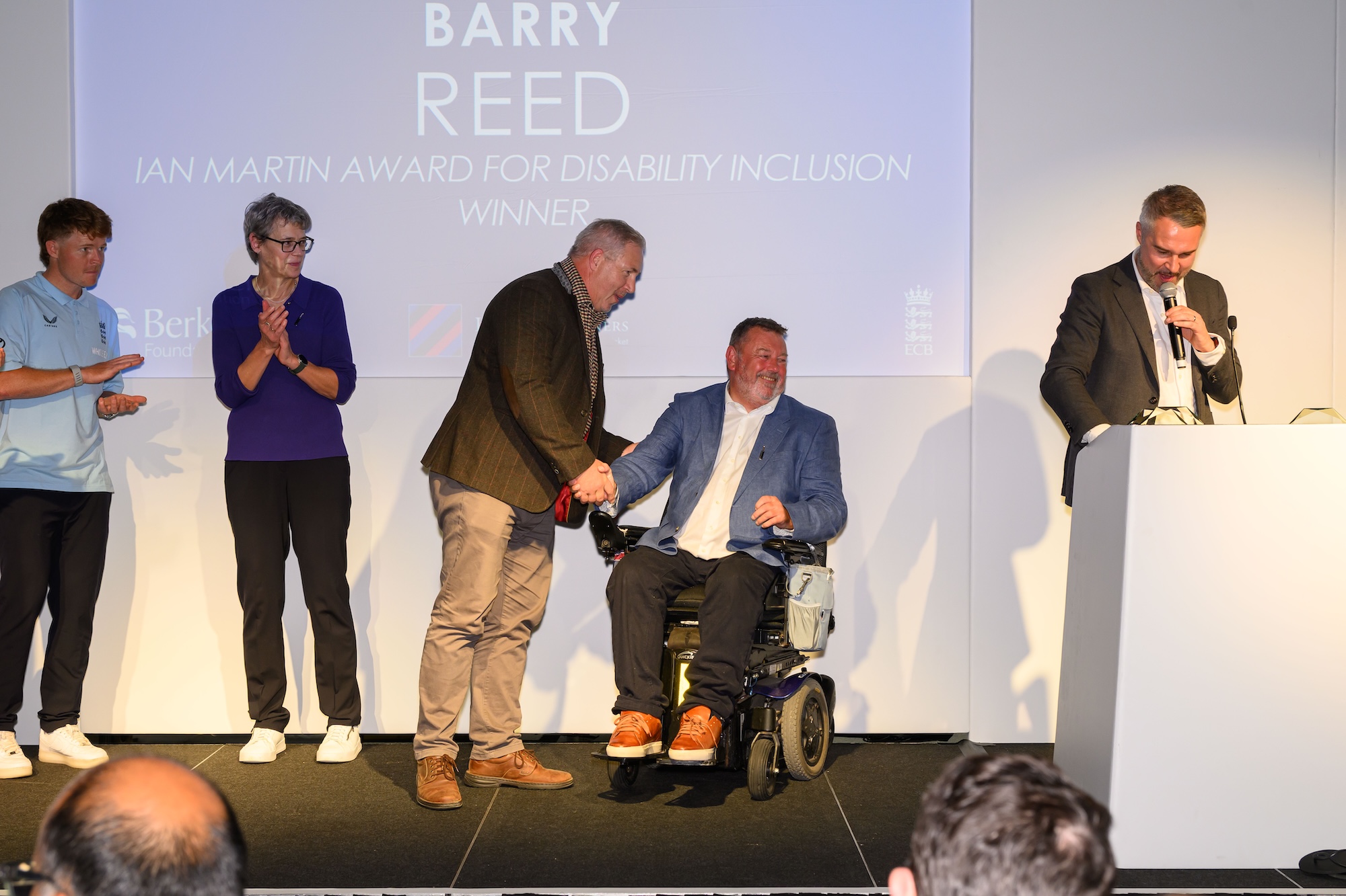 Barry Reed shaking hands with Ian Martin on stage with Ollie Pope, Lucy Pearson and Pete Graves.jpg